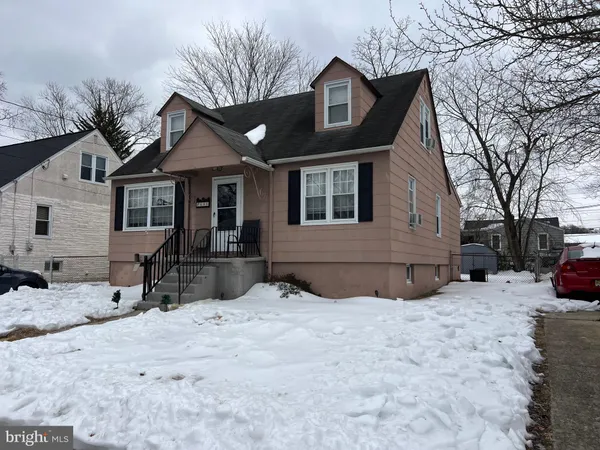 a front view of a house with a yard covered in snow