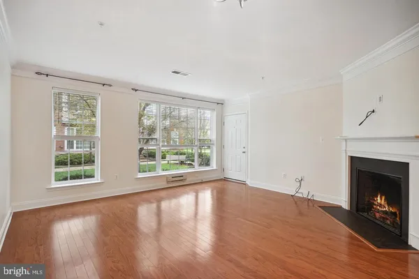 wooden floor fireplace and windows in an empty room