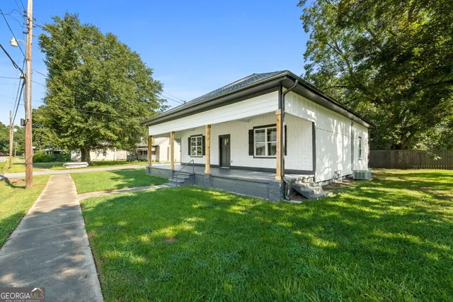a front view of a house with yard and green space