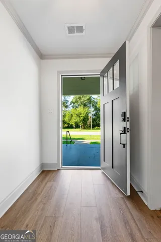 a view of empty room with floor to ceiling window and wooden floor