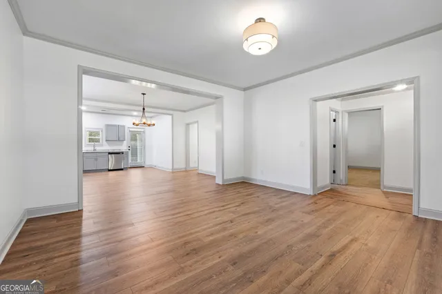 a view of empty room with wooden floor and window