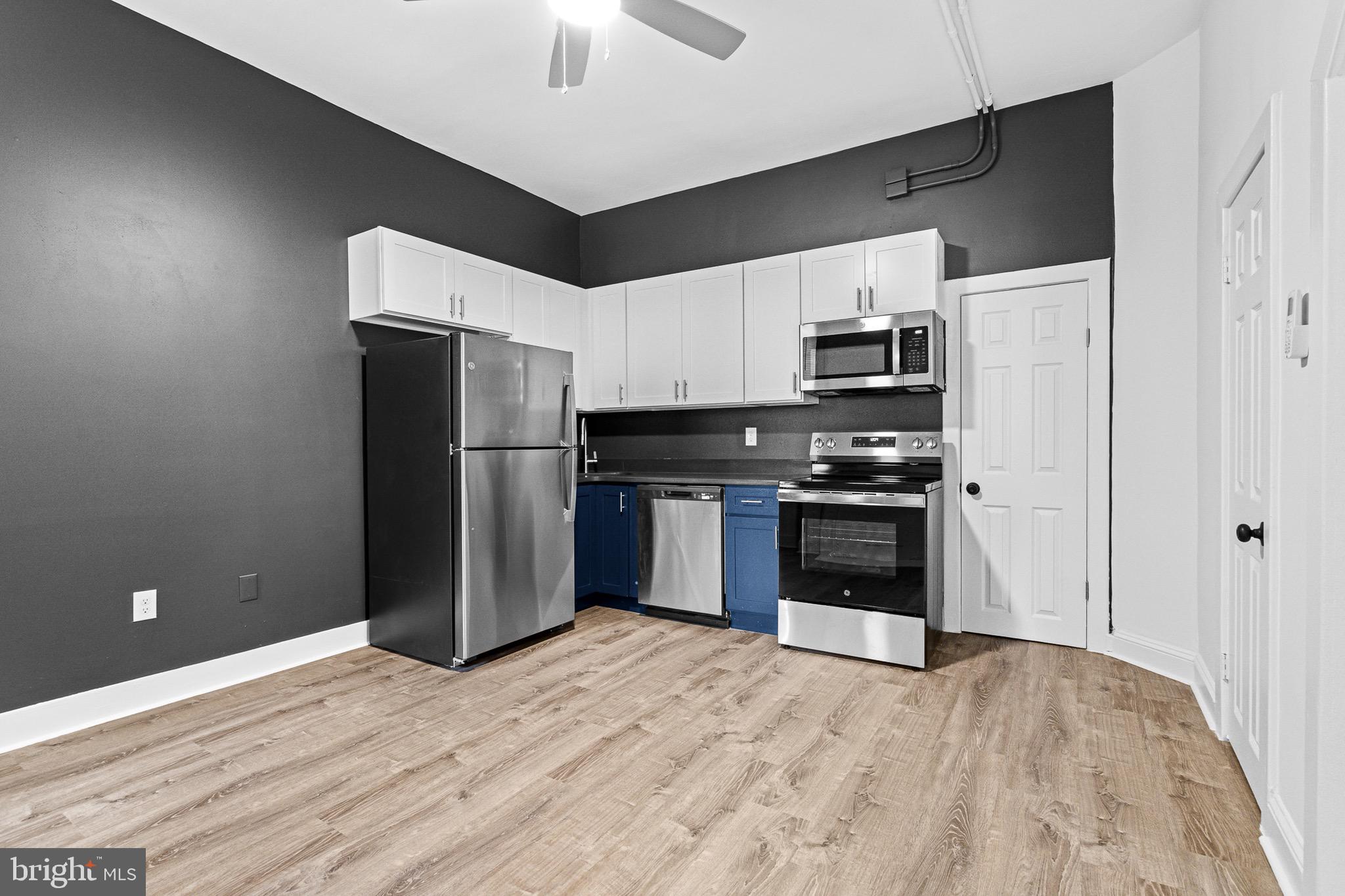 1308 West Lexington Street, Unit 2R Baltimore, MD 21223 - Photo 2 of 12 a kitchen with stainless steel appliances a refrigerator and a stove top oven