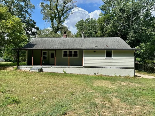a view of a house with a large pool and a large tree