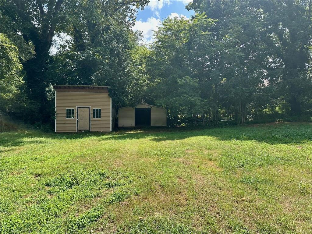 6538 North Sweetwater Road Lithia Springs, GA 30122 - Photo 13 of 16 a backyard of a house with lots of green space and large trees