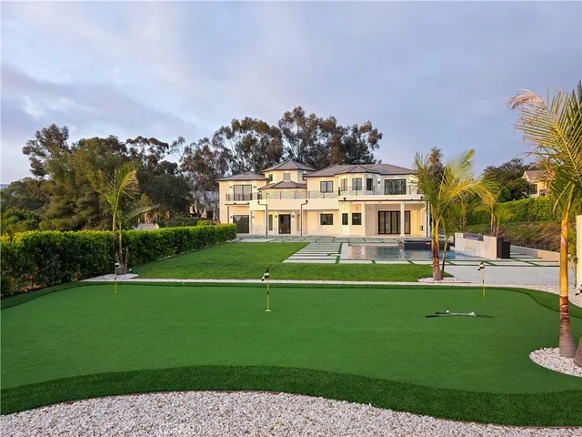 a view of a house with a swimming pool and a yard