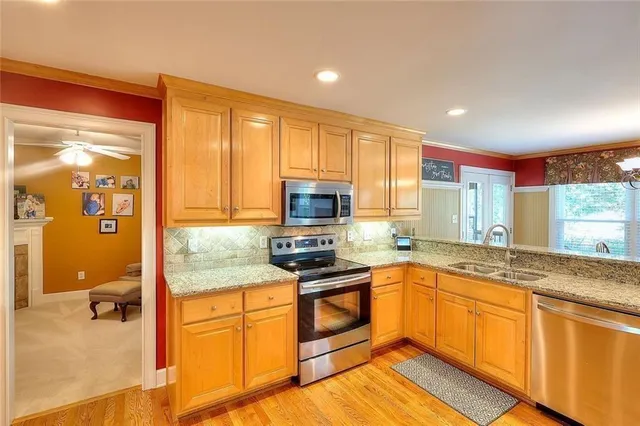 a kitchen with stainless steel appliances granite countertop a stove a sink and a microwave