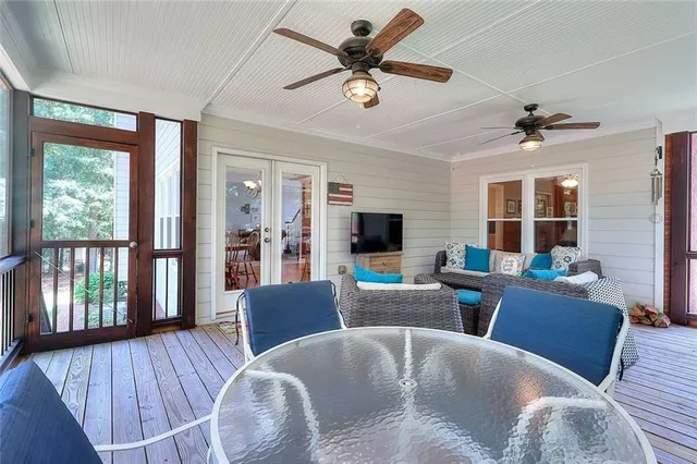 a living room with couches a coffee table and a flat screen tv with wooden floor