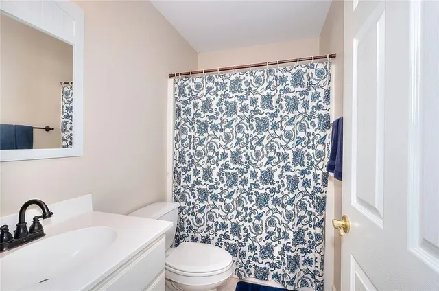 a living room with furniture a flat screen tv and kitchen view