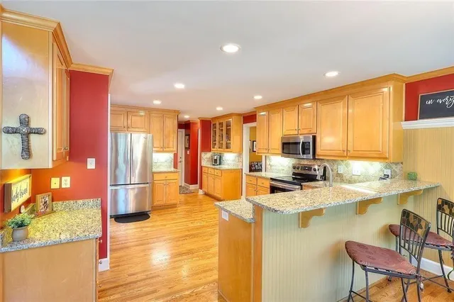 a kitchen with stainless steel appliances granite countertop a sink counter space and a refrigerator