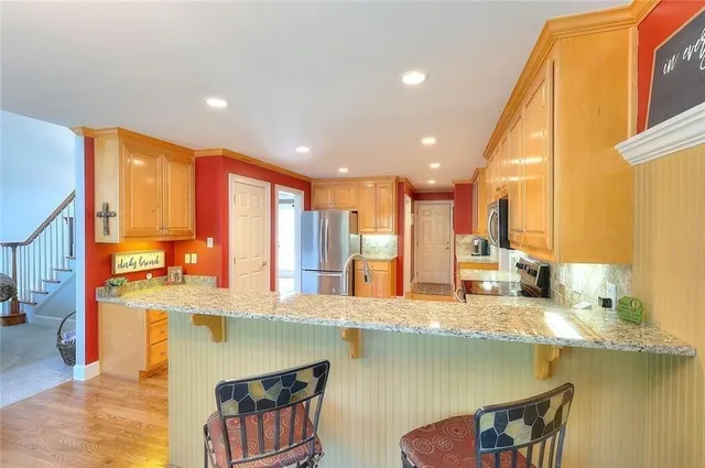 a kitchen with stainless steel appliances granite countertop a sink and a counter top space