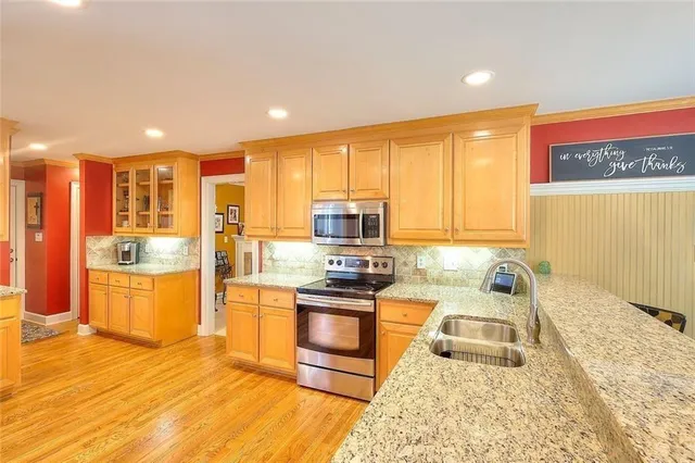 a kitchen with stainless steel appliances granite countertop a stove a sink and a microwave