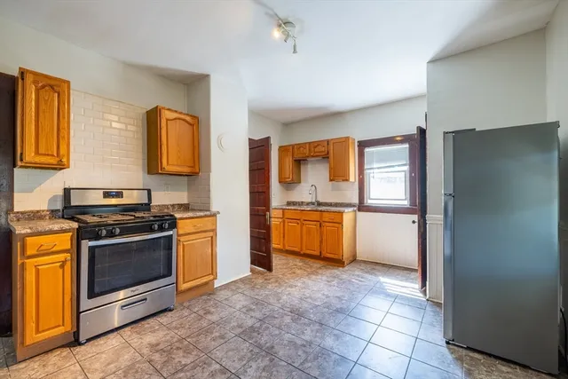 a kitchen with stainless steel appliances granite countertop a refrigerator and a stove top oven