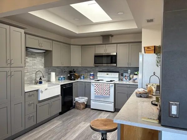 a kitchen with stainless steel appliances kitchen island granite countertop a sink cabinets and wooden floor