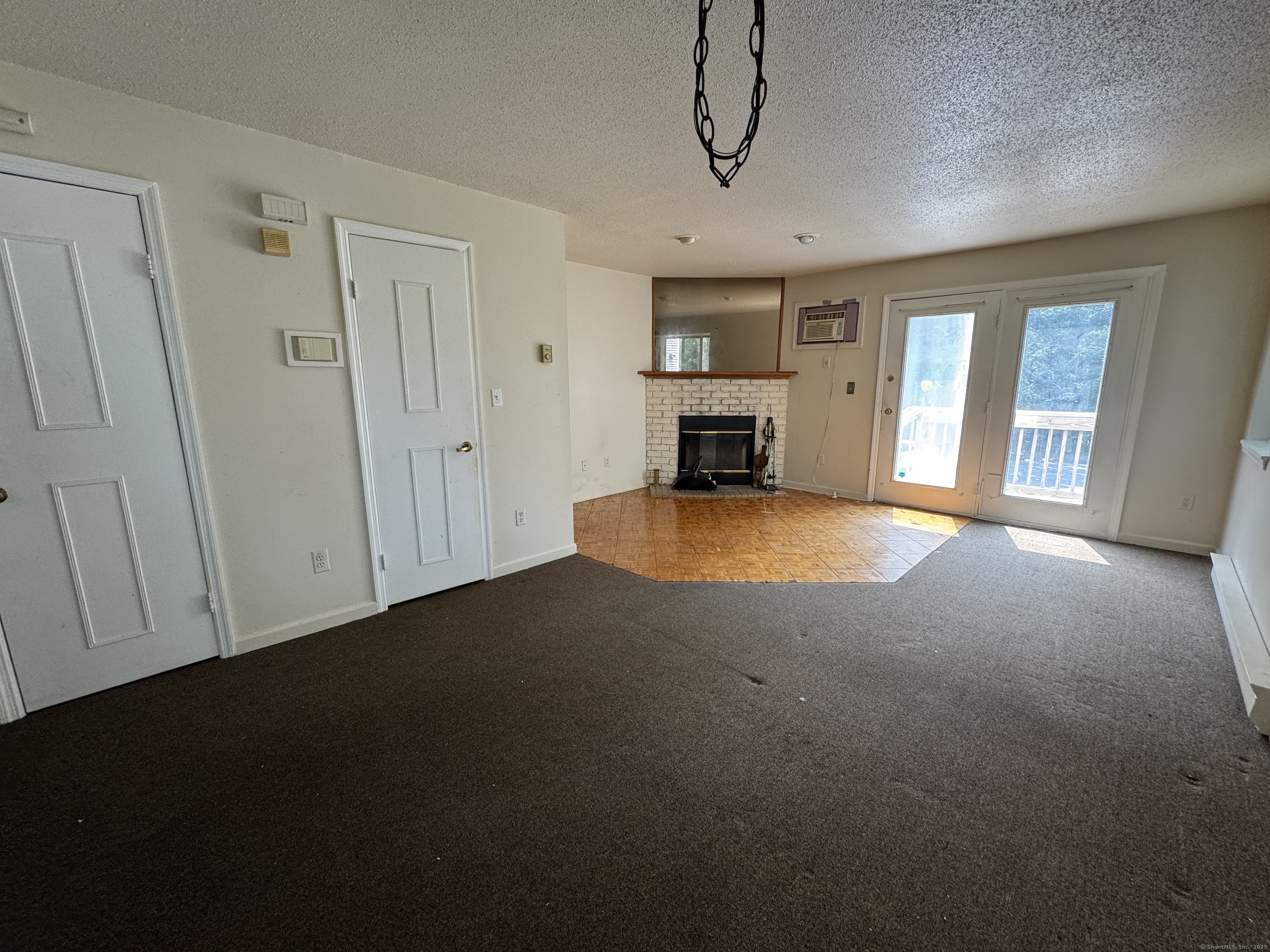 117 Hamden Avenue, Unit F Waterbury, CT 06704 - Photo 2 of 8 a view of an empty room with a fireplace and a window