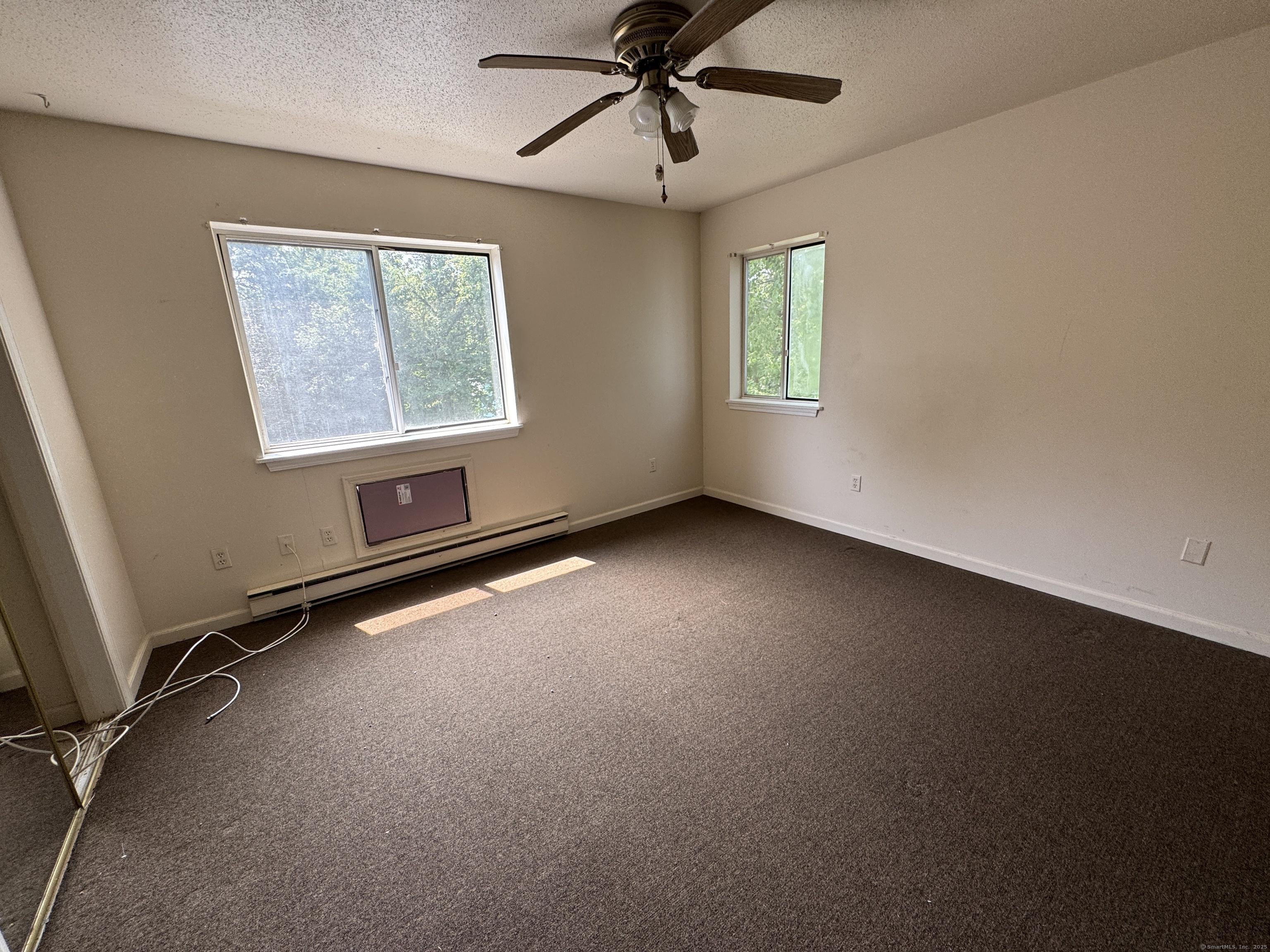 117 Hamden Avenue, Unit F Waterbury, CT 06704 - Photo 5 of 8 an empty room with windows and fan