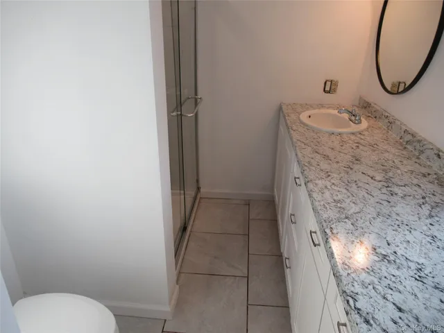 a bathroom with a granite countertop toilet and a sink