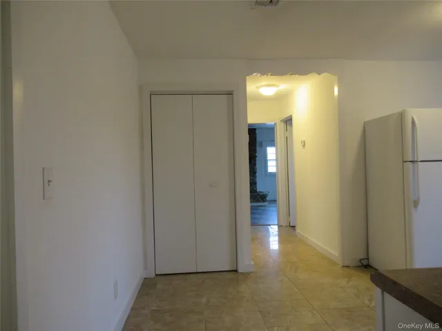 a view of a hallway with wooden shelves