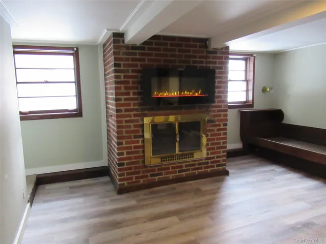 a living room with a flat screen tv a fireplace and a window