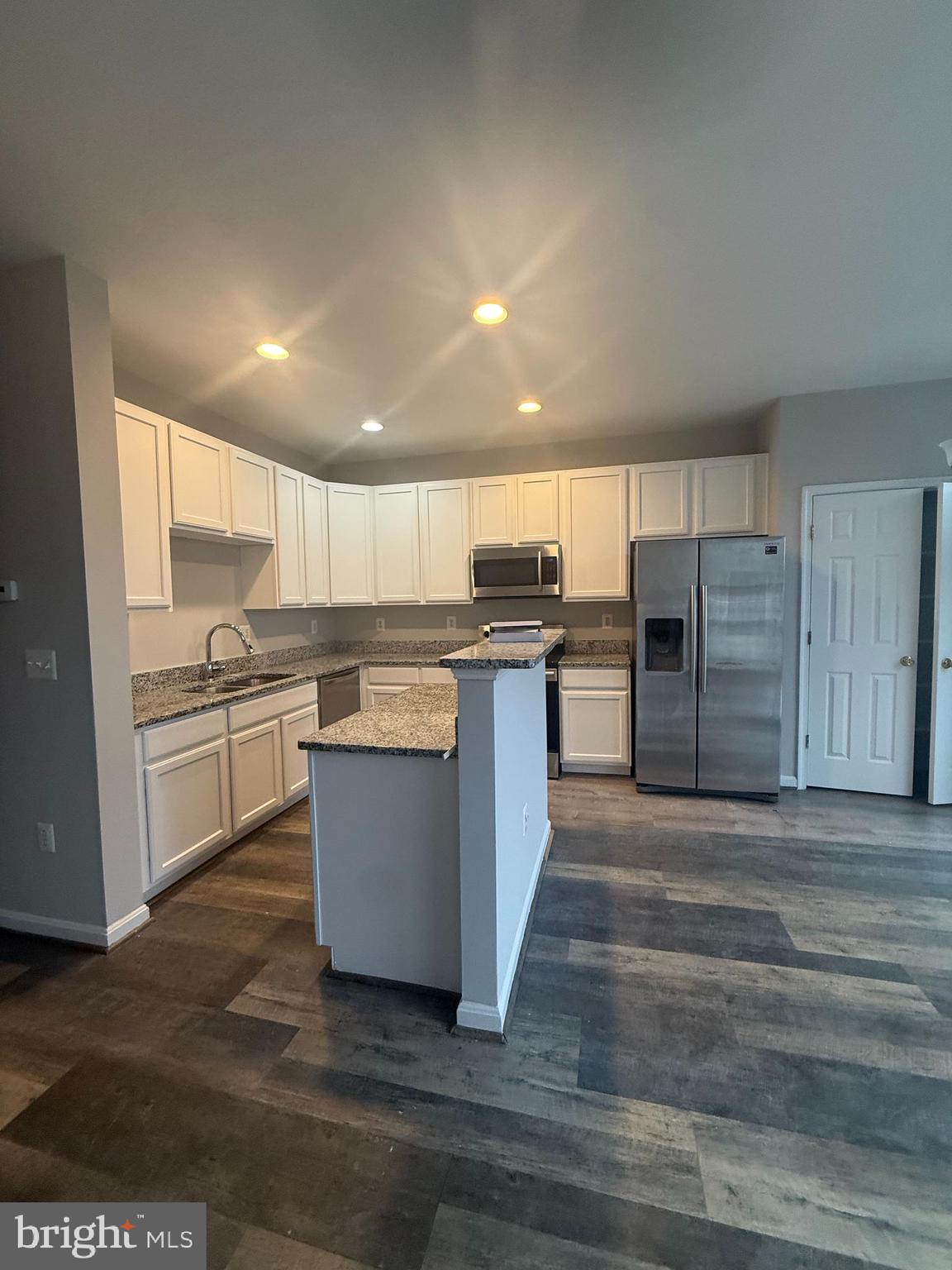 2925 Rotterdam Loop Woodbridge, VA 22191 - Photo 27 of 55 a kitchen with stainless steel appliances granite countertop a stove top oven a refrigerator and white cabinets