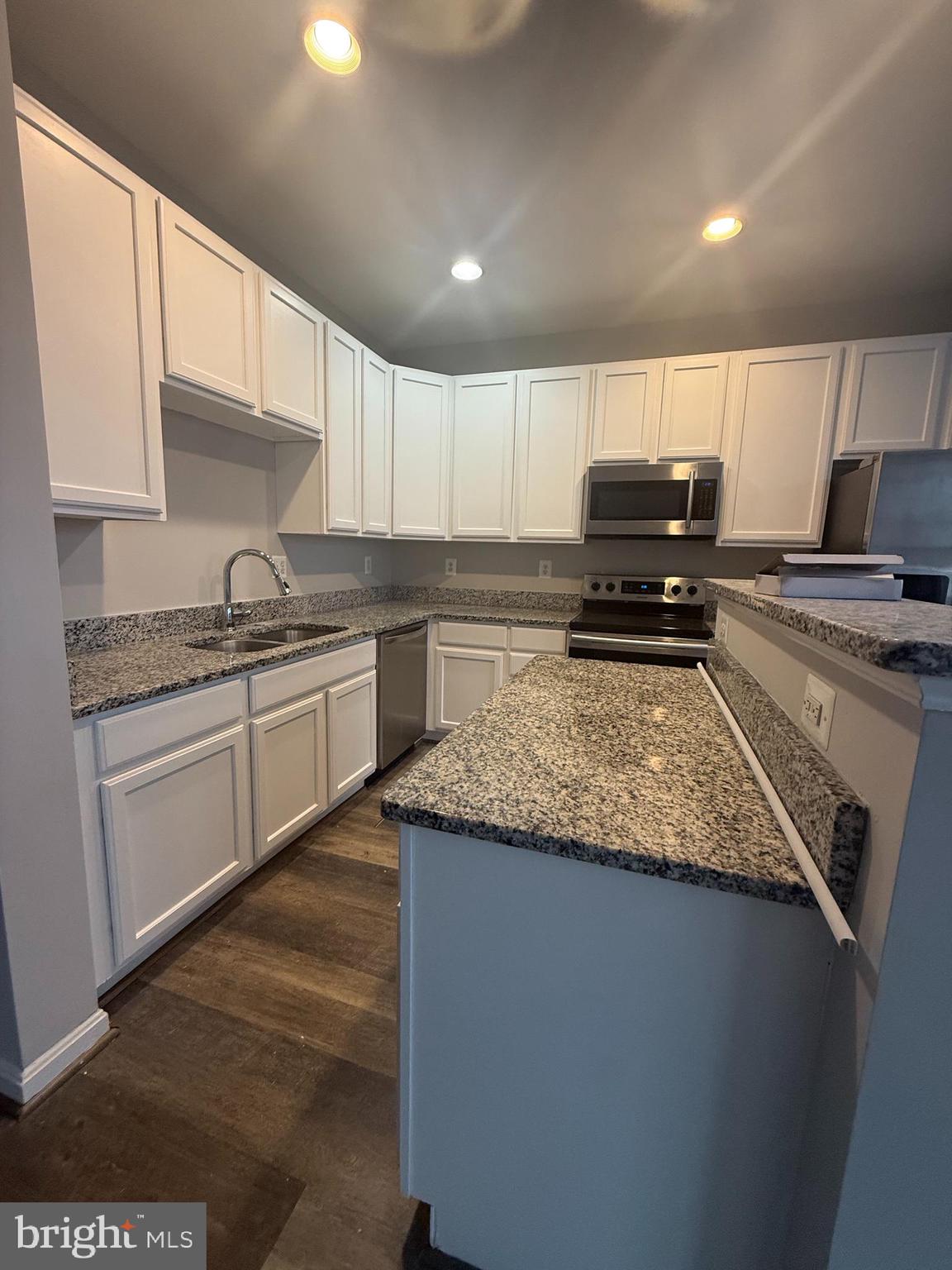 2925 Rotterdam Loop Woodbridge, VA 22191 - Photo 32 of 55 a kitchen with stainless steel appliances granite countertop a sink stove and cabinets