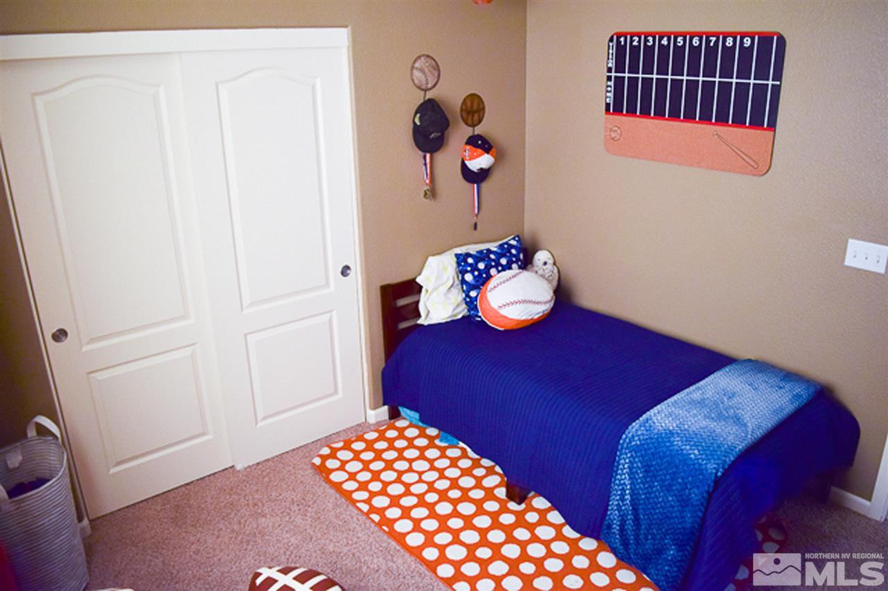 11180 Parma Way Reno, NV 89521 - Photo 21 of 37 a bedroom with a bed and wooden floor