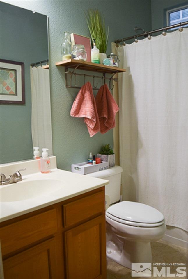 11180 Parma Way Reno, NV 89521 - Photo 24 of 37 a bathroom with a sink a toilet and a mirror