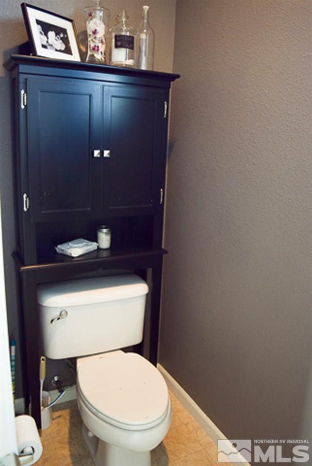 11180 Parma Way Reno, NV 89521 - Photo 29 of 37 a toilet sitting in a bathroom next to a wooden wall