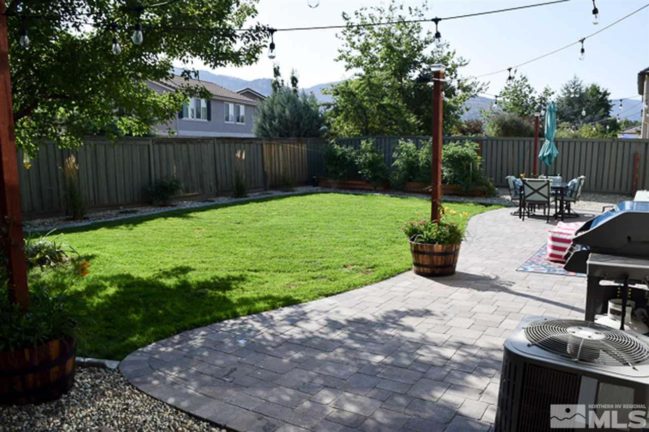 11180 Parma Way Reno, NV 89521 - Photo 35 of 37 a view of a backyard with table and chairs potted plants and wooden fence