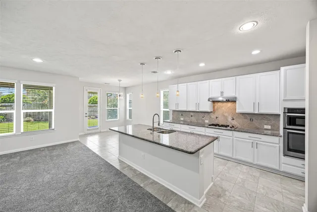 a kitchen with a sink center island stainless steel appliances and cabinets
