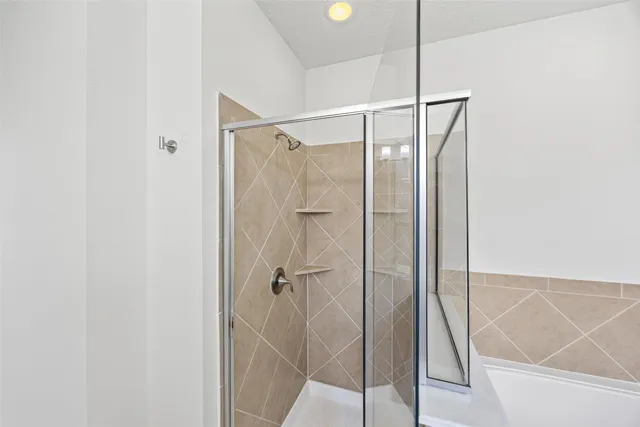 a view of an empty room with wooden floor and a ceiling fan