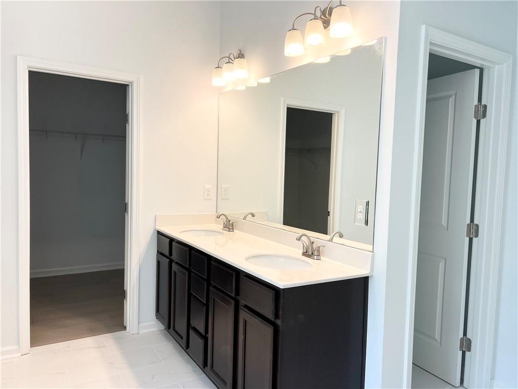 2409 Ivy Meadow Lane Buford, GA 30519 - Photo 23 of 32 a bathroom with a double vanity sink and a mirror