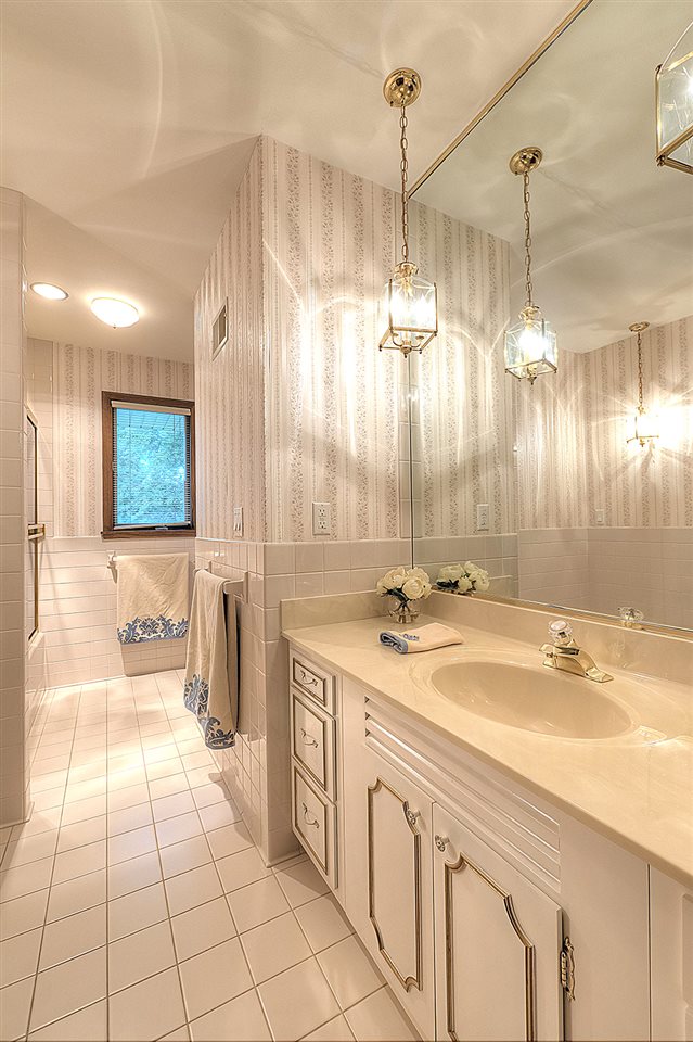 4215 Landstrom Road Rockford, IL 61114 - Photo 16 of 25 a bathroom with a sink a large mirror and a shower