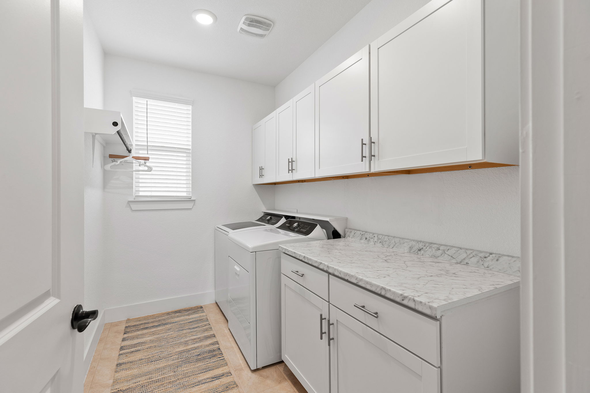 640 Martingale Street Georgetown, TX 78633 - Photo 14 of 39 Laundry room with cabinet space, washer and clothes dryer, and light tile patterned flooring