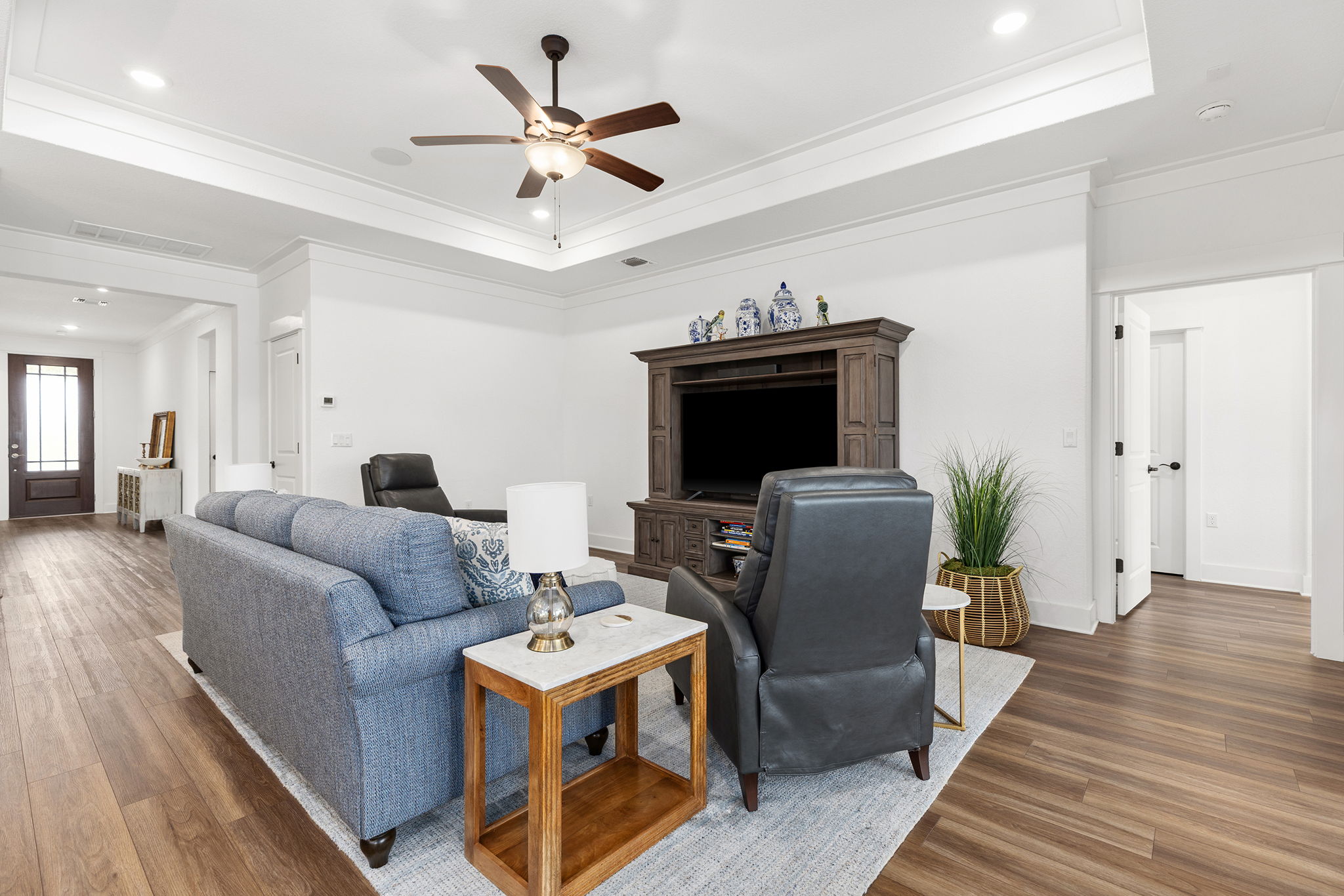640 Martingale Street Georgetown, TX 78633 - Photo 26 of 39 Living room featuring crown molding, a ceiling fan, wood finished floors, a raised ceiling, with in house speakers, and recessed lighting
