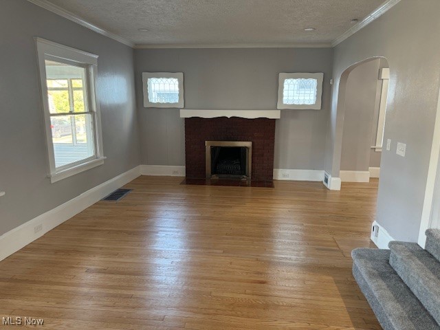 18210 Windward Road Cleveland, OH 44119 - Photo 13 of 40 Unfurnished living room with light wood-type flooring, ornamental molding, and a textured ceiling