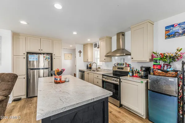 a kitchen that has a lot of cabinets a sink and appliances in it