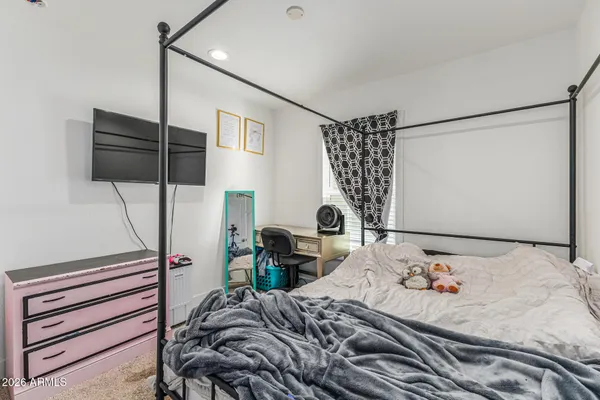 a bedroom with a bed a desk and chair