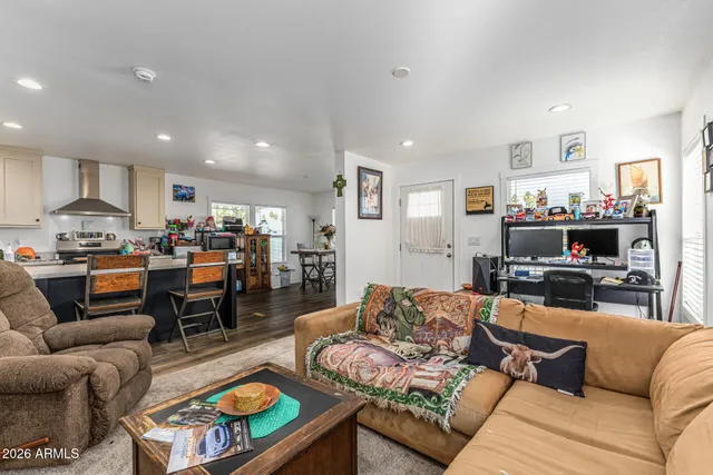 a living room with furniture kitchen view and a window