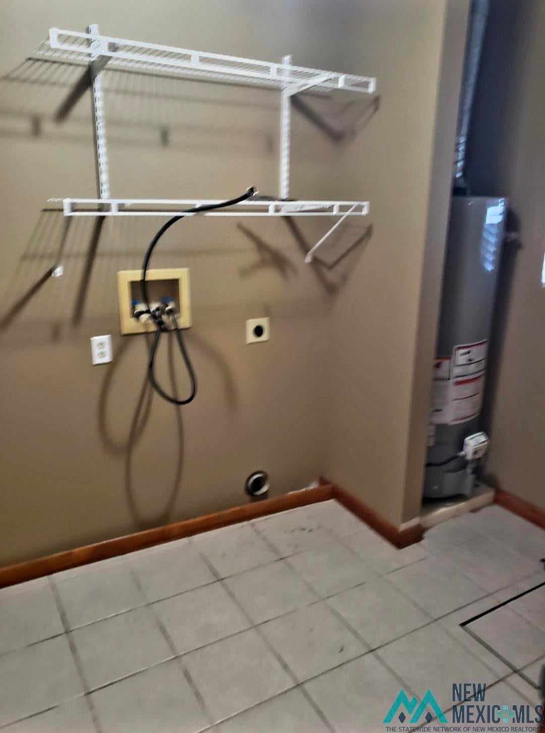 1375 Brilliant Street Raton, NM 87740 - Photo 17 of 19 Laundry room with washer hookup, gas water heater, light tile patterned flooring, and hookup for an electric dryer