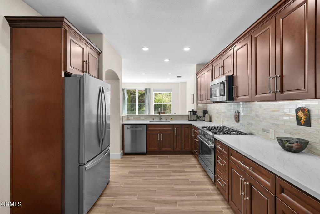 596 Fenwick Way, Unit C Simi Valley, CA 93065 - Photo 18 of 45 a kitchen with stainless steel appliances granite countertop a refrigerator a sink dishwasher a stove top oven a refrigerator and cabinets
