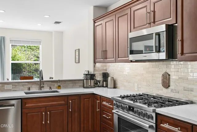 a kitchen with granite countertop a stove sink and cabinets