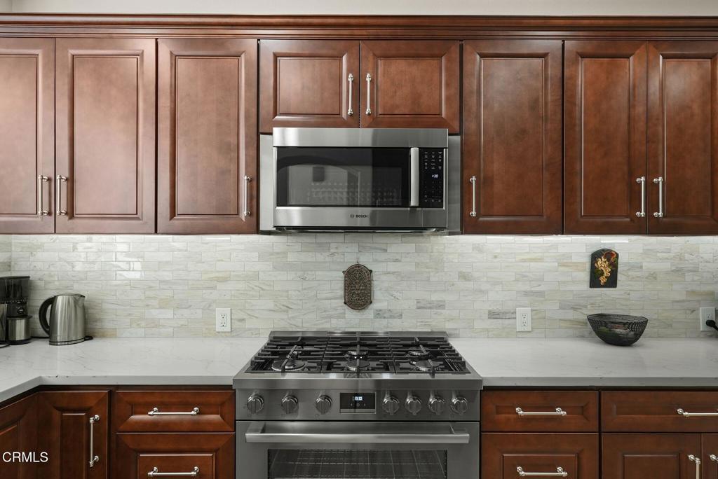 596 Fenwick Way, Unit C Simi Valley, CA 93065 - Photo 22 of 45 a kitchen with granite countertop a stove sink and cabinets