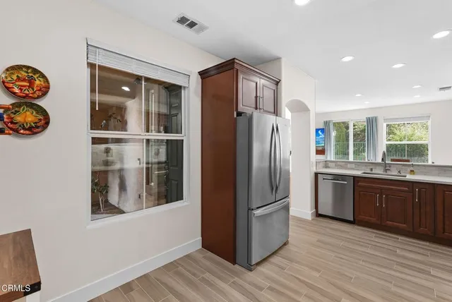 a kitchen with stainless steel appliances granite countertop a refrigerator and a stove top oven