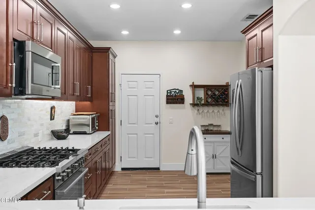 a kitchen with stainless steel appliances granite countertop a stove a sink and a refrigerator