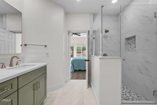 a en suite bathroom with a sink a mirror and shower