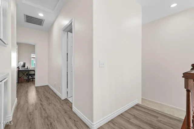a view of a hallway with wooden floor