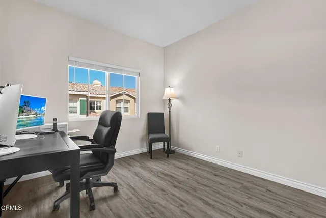 a view of a workspace with furniture and wooden floor