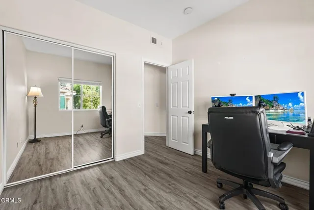 a view of a workspace with furniture and wooden floor