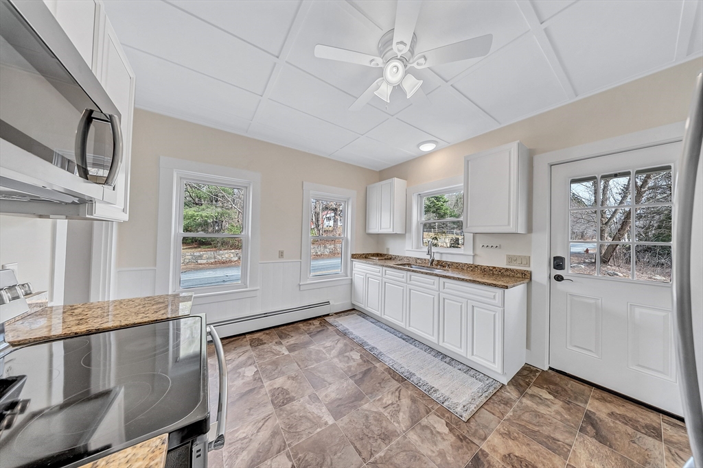 375 South Main Street Burrillville, RI 02859 - Photo 4 of 39 a large white kitchen with granite countertop a large window and white cabinets