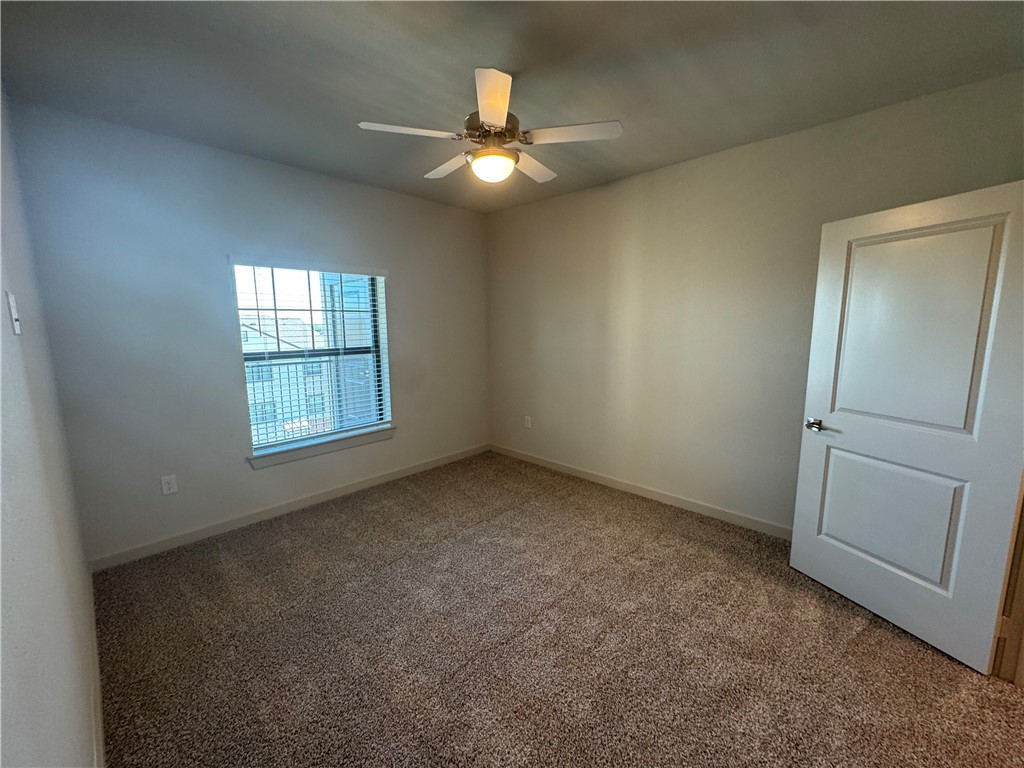 6000 Jones Road, Unit 4202 Bryan, TX 77807 - Photo 16 of 19 an empty room with windows and chandelier fan